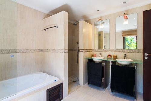 uma casa de banho com 2 lavatórios e uma banheira em VILLA ANDALUCIA ATLANTIDA, casa con piscina privada em Alhaurín de la Torre