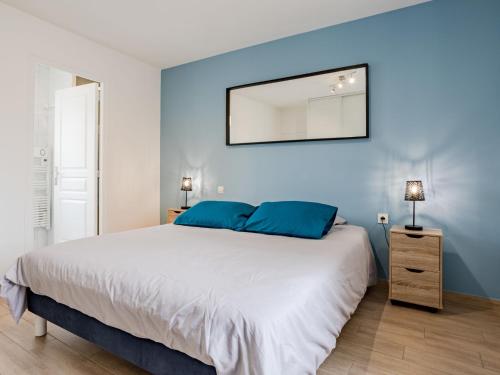 une chambre avec un grand lit aux murs bleus dans l'établissement Holiday Home La peite maison by Interhome, à Gouville-sur-Mer