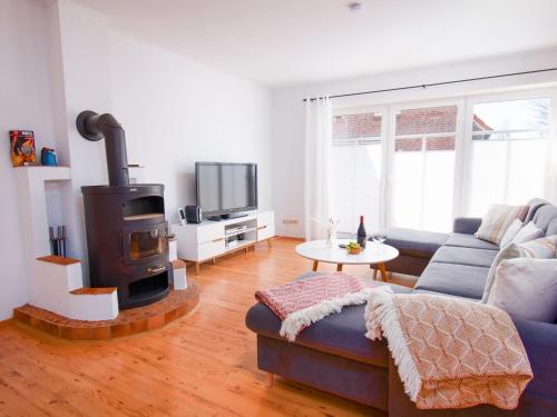 a living room with a couch and a wood stove at Holiday Home Kiek in by Interhome in Norden