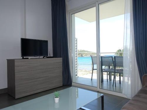 een woonkamer met een tv en een glazen schuifdeur bij Apartment Villa Tyrrenia-4 by Interhome in Rogliano