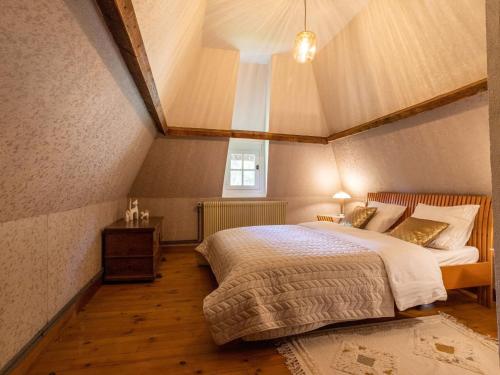 une chambre avec un grand lit dans un grenier dans l'établissement Holiday Home La Chaumière by Interhome, à Saint-Georges-du-Mesnil