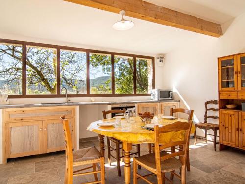 cocina con mesa de madera y algunas ventanas en Holiday Home Le Cabanon by Interhome en Besse-sur-Issole