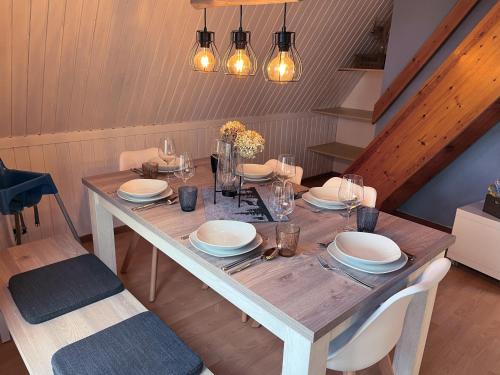 a dining room table with plates and glasses on it at Chalet Waldrauschen by Interhome in Bad Arolsen
