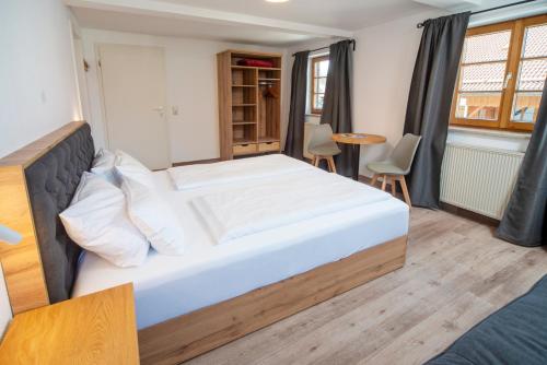 a bedroom with a large bed and a table at Landgasthof Hanselewirt in Schwangau