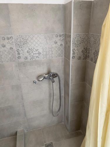 La salle de bains est pourvue d'une douche avec rideau de douche. dans l'établissement Popi Studios, à Kos