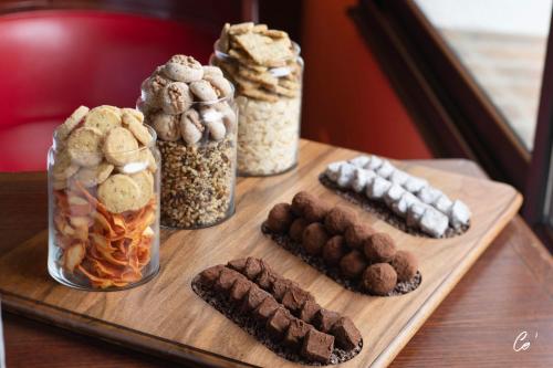 a wooden table with jars of cookies and other desserts at Georges Blanc Parc & Spa in Vonnas