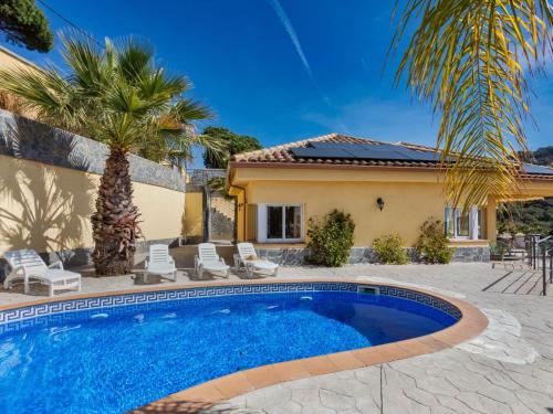 einen Pool vor einem Haus mit einer Palme in der Unterkunft Holiday Home Floradise by Interhome in Lloret de Mar