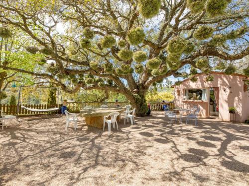 un patio avec une table et des chaises sous un arbre dans l'établissement Holiday Home La Renardière by Interhome, à Le Tignet