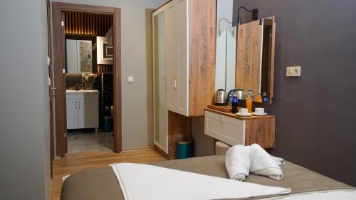 a bedroom with a bed and a vanity and a mirror at FİDAN CİTY HOTEL in Istanbul