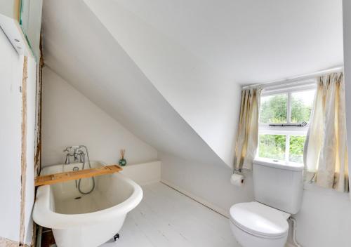 a white bathroom with a toilet and a sink at Coppers in Lavenham