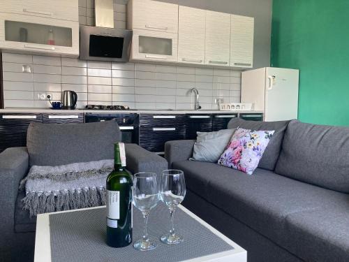a living room with a couch and two wine glasses at Apartament Villa Olivia in Szczebrzeszyn