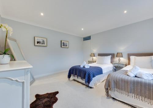 two beds in a room with white walls at Dakings in Halesworth