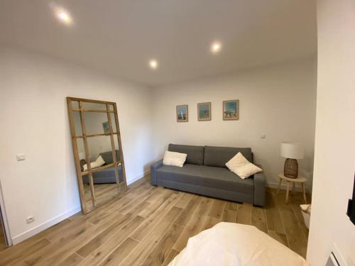 a living room with a couch and a mirror at VILLA Arcachon 12 pers AVEC PISCINE chauffée 1 mai au 30 sept in Arcachon