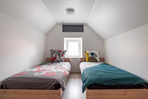 een slaapkamer met 2 bedden op een zolder bij Gite Le Carpe Diem - Classé 3 étoiles - Centre ville - Wifi - Netflix in Marmoutier