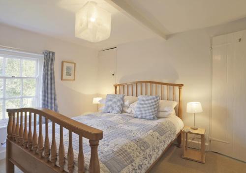sypialnia z drewnianym łóżkiem z niebieskimi poduszkami w obiekcie Easter Cottage w mieście Westleton