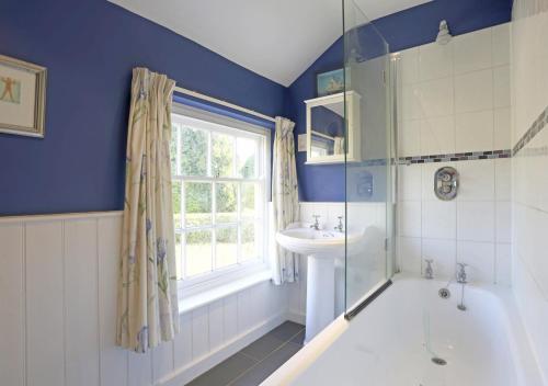 łazienka z wanną, umywalką i oknem w obiekcie Easter Cottage w mieście Westleton