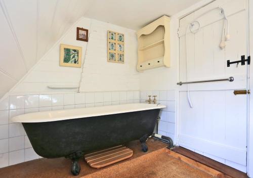 Hemley的住宿－Eelsfoot Cottage，一间位于客房内的带黑色浴缸的浴室