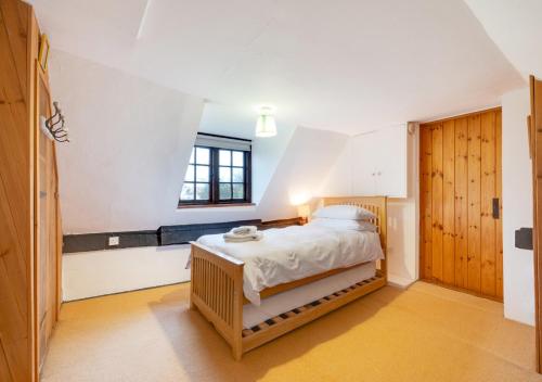 um quarto com uma cama e uma janela em Eelsfoot Cottage em Hemley