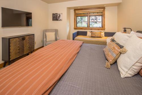 a bedroom with a large bed with a flat screen tv at Alpenglow Condo 36A in Big Sky