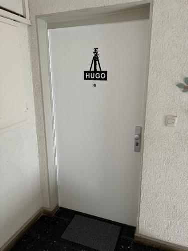 uma porta branca com um sinal preto em Hugo em Gelsenkirchen