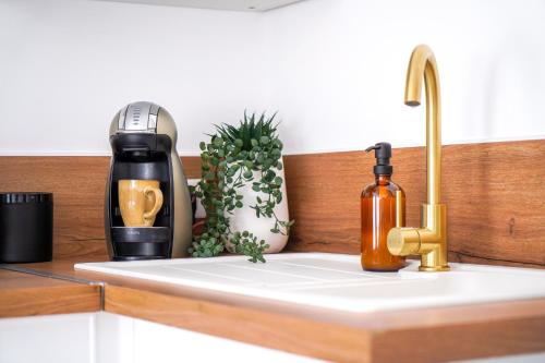 a kitchen counter with a coffee maker and a sink at Le Petit Martial - coeur de ville,refait à neuf,tout équipé, parking in Châteauroux