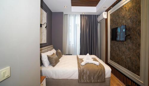 a hotel room with a bed and a tv at FİDAN CİTY HOTEL in Istanbul