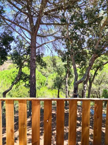 a wooden fence with trees in the background at Cabanas de Melides in Melides
