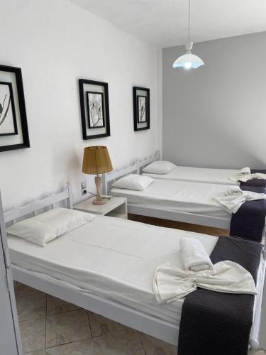 two beds in a room with white walls at Popi Studios in Kos