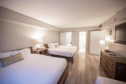 a hotel room with two beds and a flat screen tv at Stay Together Suites - Spacious Condominium On The Strip Sleeps 12 - NO RESORT FEE in Las Vegas