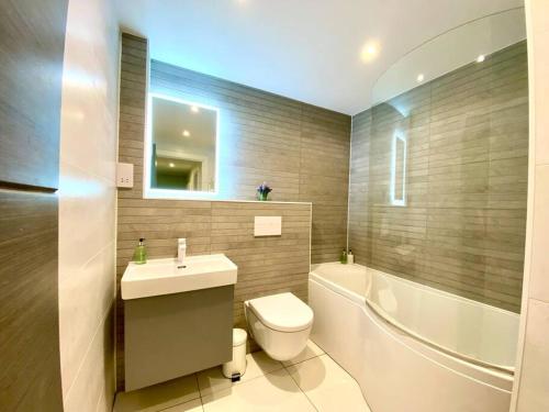 a bathroom with a toilet and a sink and a tub at Stunning 3 bedroom Penthouse Apartment - Free Parking & WiFi - 1 Minute walk to Poole Quay - Great Location - Free Parking - Fast WiFi - Smart TV - Newly decorated - sleeps up to 6! Close to Poole & Bournemouth & Sandbanks in Poole