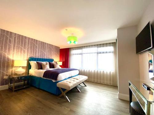 a bedroom with a blue bed and a window at Stunning 3 bedroom Penthouse Apartment - Free Parking & WiFi - 1 Minute walk to Poole Quay - Great Location - Free Parking - Fast WiFi - Smart TV - Newly decorated - sleeps up to 6! Close to Poole & Bournemouth & Sandbanks in Poole