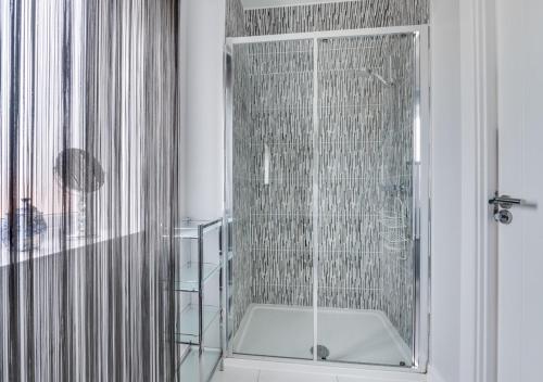 a shower with a glass door in a bathroom at Felsto Beach in Felixstowe