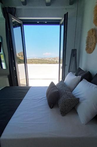 a bedroom with a bed with a view of a beach at Passa Corda Suites with amazing view in Galanado