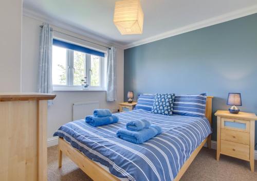 a bedroom with a bed with blue towels on it at Field End in Reydon