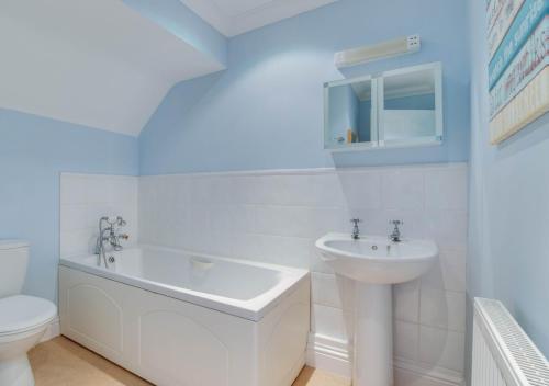 uma casa de banho com um lavatório, uma banheira e um WC. em Field End em Reydon