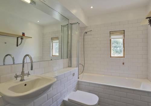 a bathroom with a sink and a toilet and a tub at Glenview in Bramfield