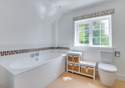 a white bathroom with a tub and a toilet at Gleve House in Marlesford