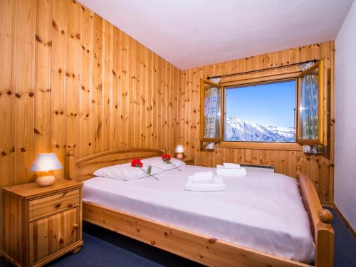 a bedroom with a large bed with a window at Chalet OnThePiste in La Tzoumaz