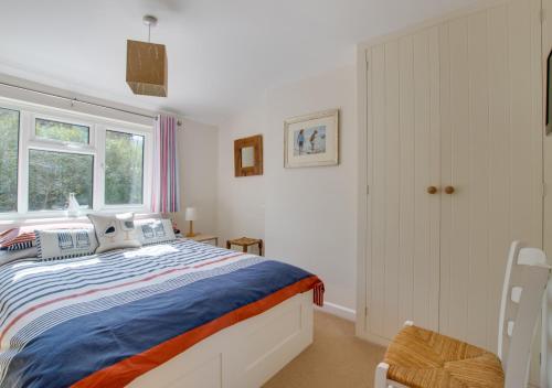 a white bedroom with a bed and a window at Heather View in Middleton