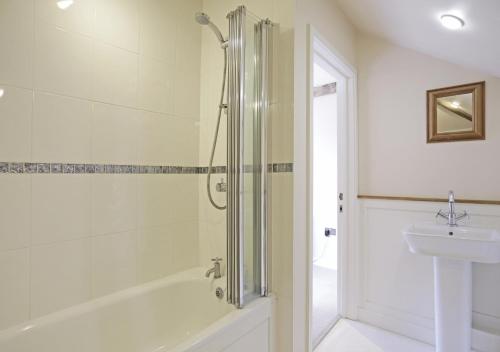 a bathroom with a shower and a sink at Harrow Cottage in Yoxford