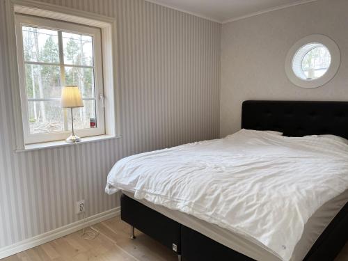 - une chambre avec un lit blanc et une fenêtre dans l'établissement Newly built cottage located on a lake plot by Lake Flaten, à Järnforsen