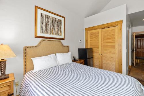 a bedroom with a bed with a striped comforter at Telluride Mountain Lodge Skiin Out amazingLocation in Telluride
