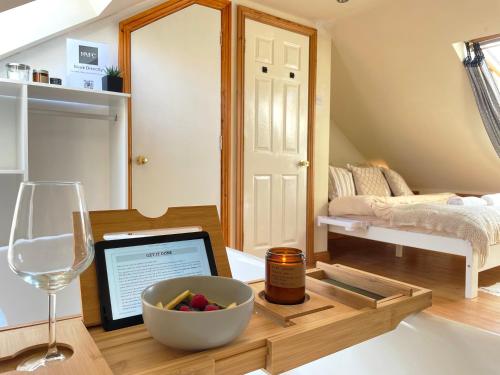 um quarto com uma mesa com uma taça de fruta e um copo de vinho em Mini-studio by HNFC Stays em South Shields