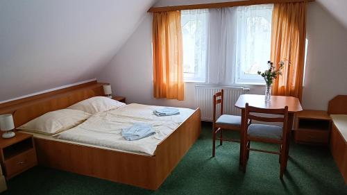 1 dormitorio con 1 cama, mesa y sillas en Motel Velký Rybník en Pelhřimov