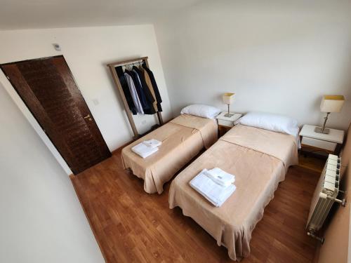 two beds in a room with wooden floors at Alquilo Casa Luminosa y Amplia en Viedma in Viedma