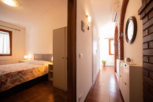 1 dormitorio con 1 cama en una habitación con una pared de ladrillo en Dimora Stellina - Isola di Pellestrina Ve, en Pellestrina