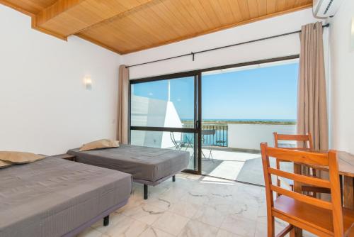 カバナス・デ・タビラにあるCabanas Ria Sea View By Algarturのベッドルーム1室(ベッド2台付)が備わり、海の景色を望めます。
