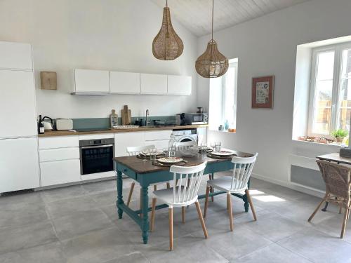 una cocina con una mesa azul y sillas. en La Maison de Lena 500m de la Plage en Barbâtre