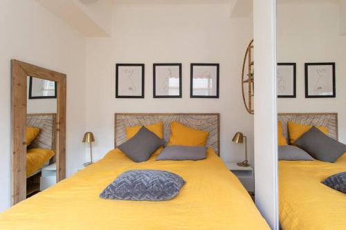 - une chambre avec un lit jaune et un miroir dans l'établissement L24 Meyerbeer Promenade 1min SEA & Negresco AC/Balcony, à Nice