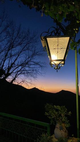 a street light with the sunset in the background at Auberge des Cascades Imouzzer - Paradise Valley in Imouzzer des Ida Ou Tanane